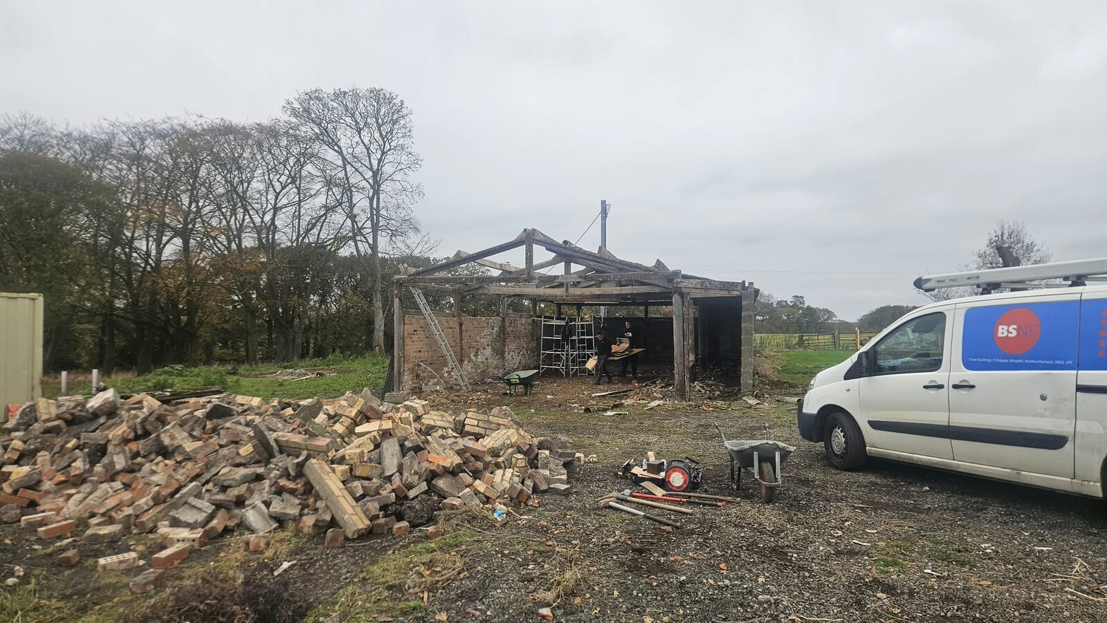The stone barn before work started, roof open and the yard full of rubble