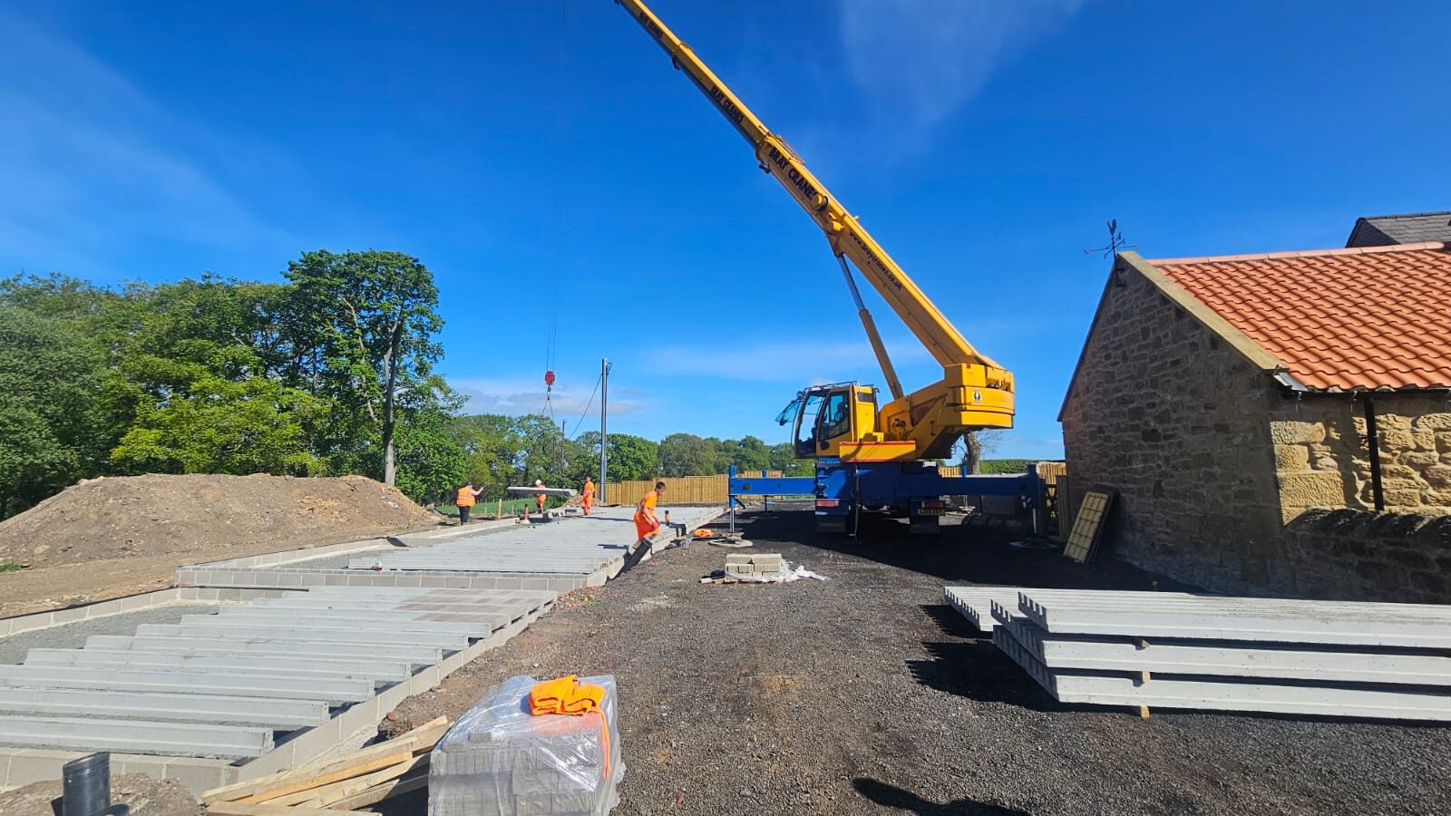 A crane setting floor slabs beside the original stone shell