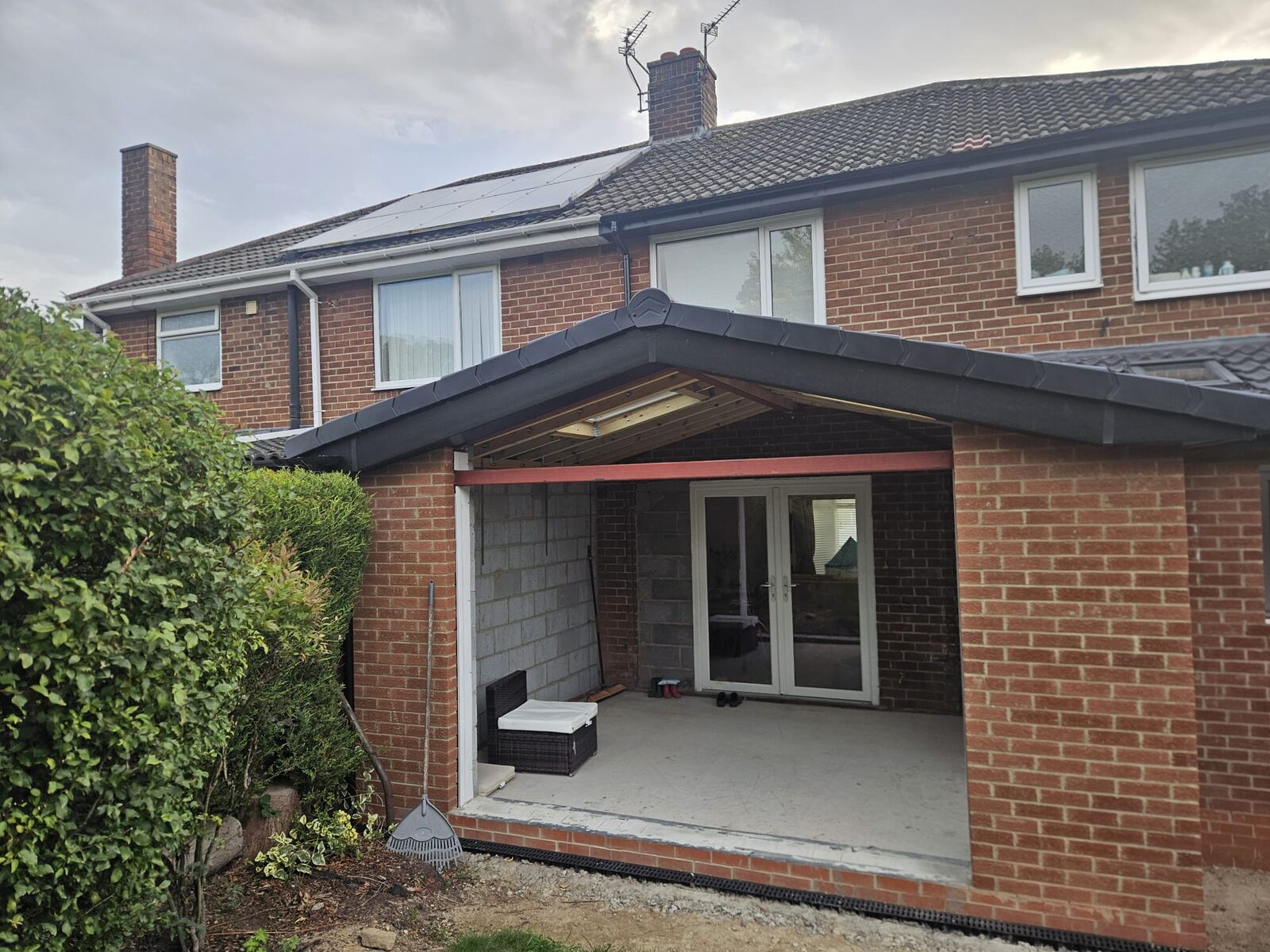 A rear extension in brick with a grey tiled roof, awaiting its bifold doors.