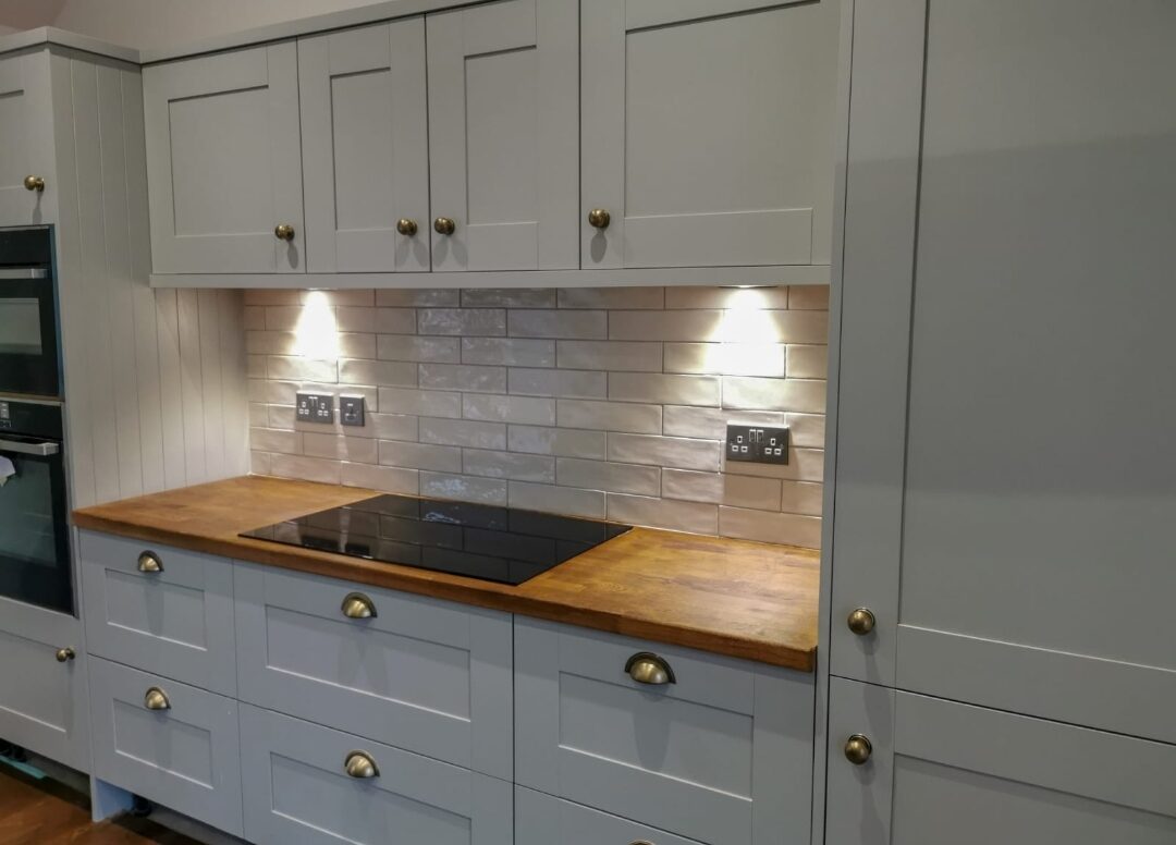 Induction hob set into an oak worktop with brass handles.