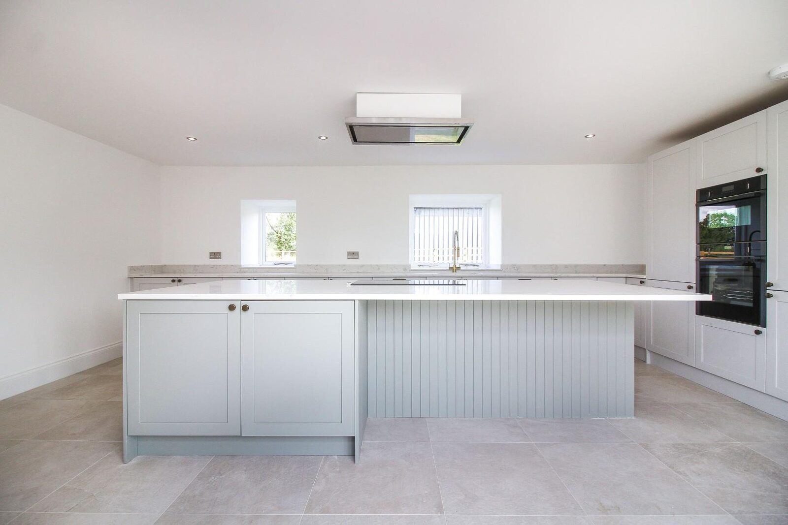 The same white kitchen and island, seen across the room.